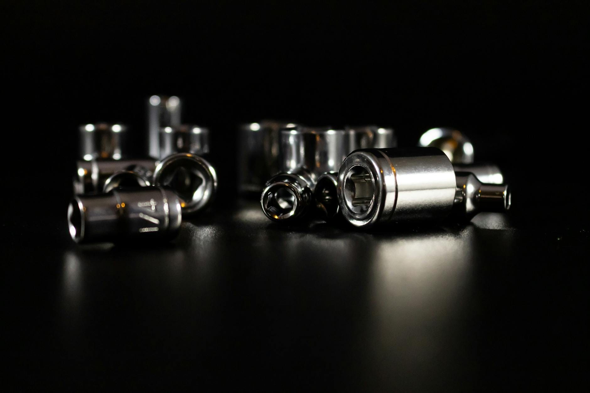 Chromowane klucze nasadowe w zbliżeniu na ciemnym tle