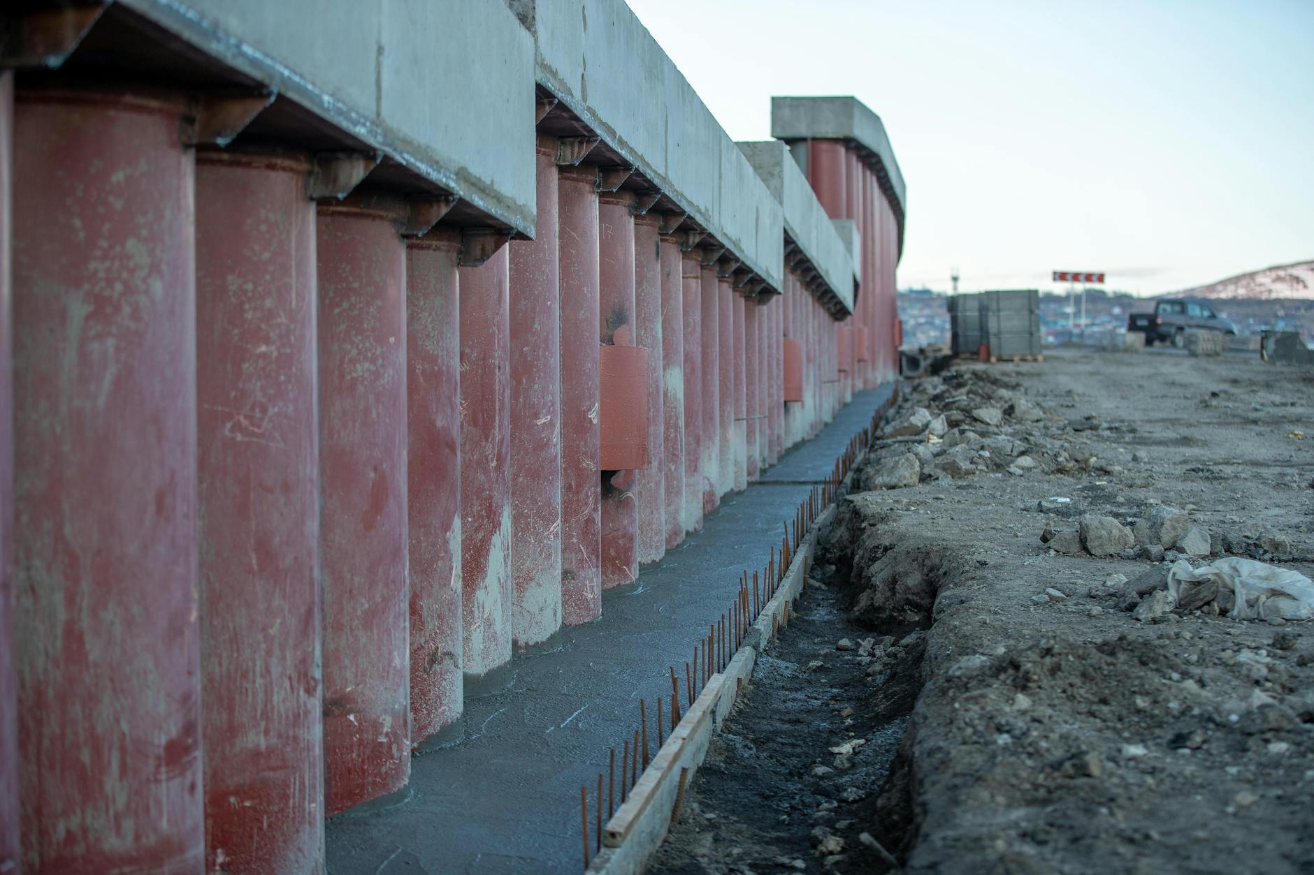 Plac budowy z dużymi słupami betonowymi i ciężkim sprzętem